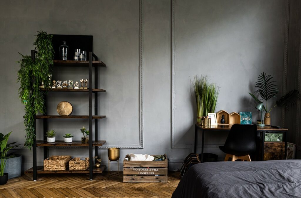 Intérieur style industriel avec des couleurs bois et des nuances de gris, cet intérieur est un exemple de décoration loft avec du métal noir, des plantes, des murs badigeonnés à l'enduit décoratif d'intérieur à la chaux et du bois.