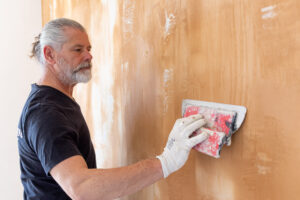 Fred, formateur de Créaconcept qui applique un effet béton en deux teintes sur un mur