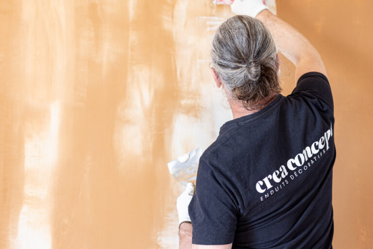 Applicateur entrain de parer un mur en effet béton