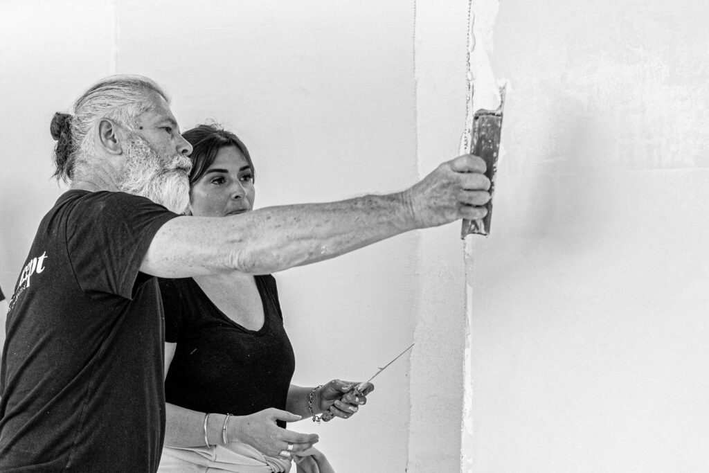 Le formateur du centre de formation qui accompagne une stagiaire dans l'application du mortier